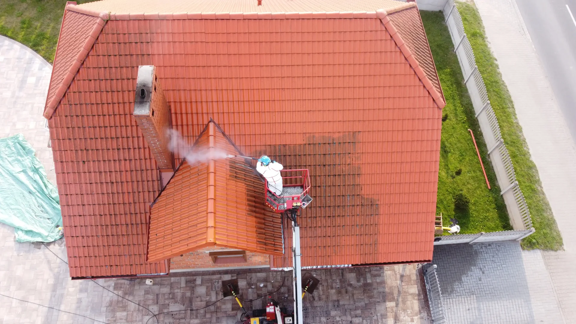 Pracownik myjący panele fotowoltaiczne na dachu